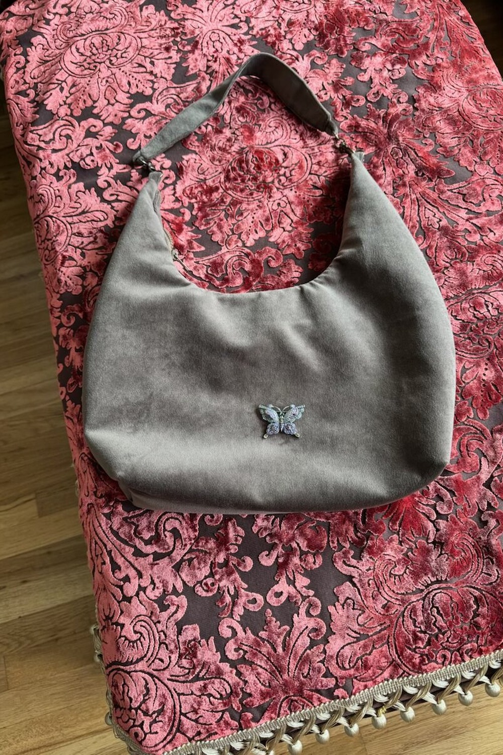 Pewter grey velvet hobo with a small embroidered butterfly, on coral pink damask velvet.